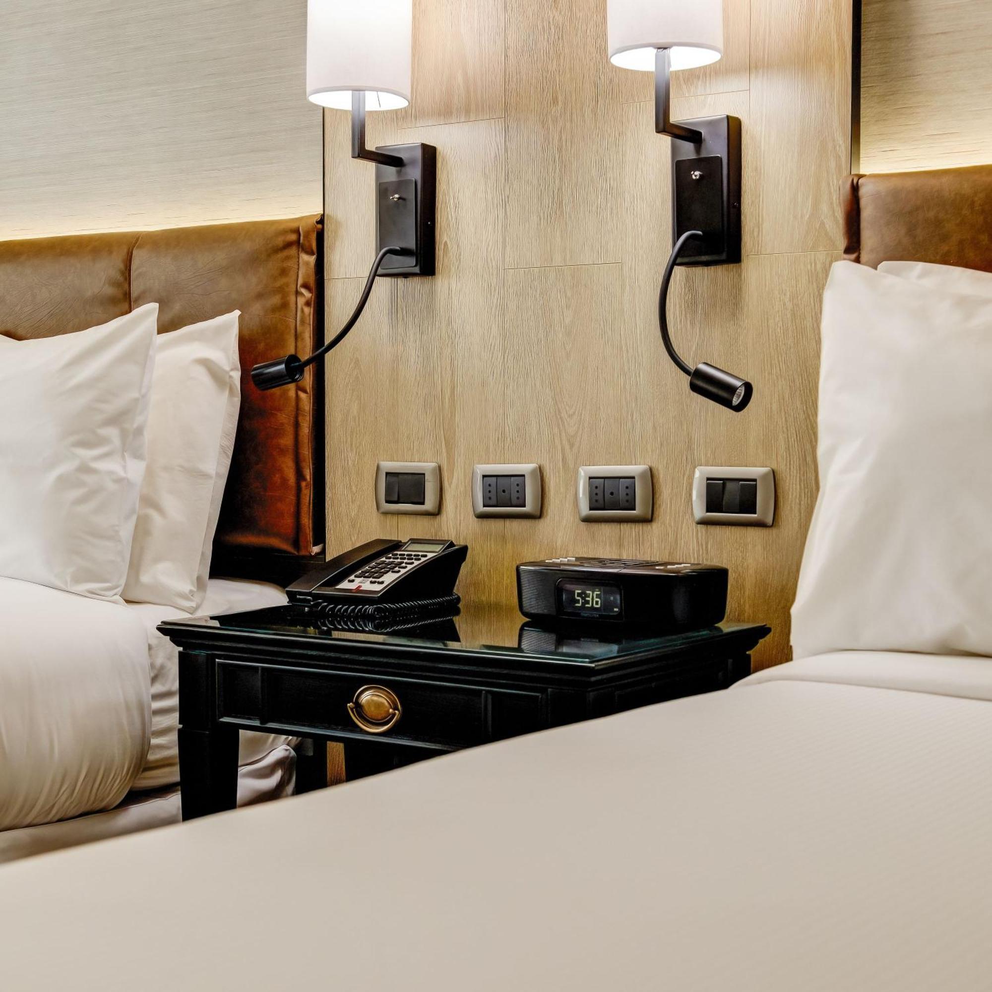 Plaza El Bosque Ebro Hotel Santiago Kültér fotó A bedside table with a telephone and a digital alarm clock